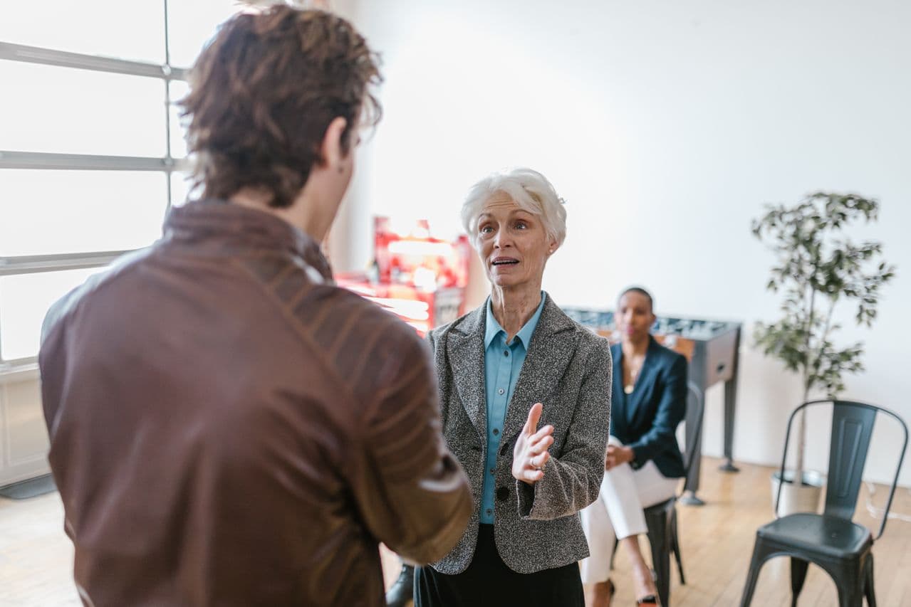 senior businesswoman talking with younger male